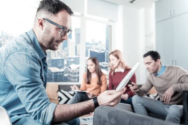 Belgeyi tutarak ve o bakan gözlüklü düşünceli adam.