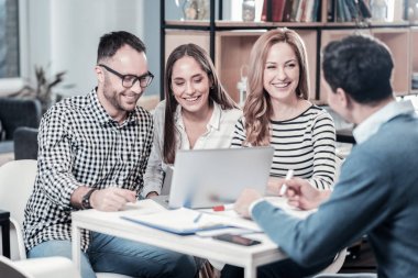 Oturma ve görev tartışırken neşeli memnun şirket.