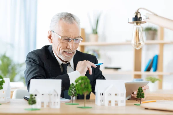 Zufriedener Immobilienmakler lächelt, während er seine Arbeit beendet — Stockfoto