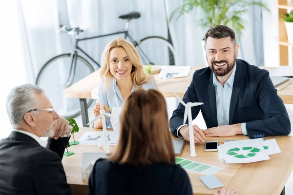 Slimme vrolijke ingenieurs glimlachen terwijl het werken bij nuttig windmolen turbines — Stockfoto