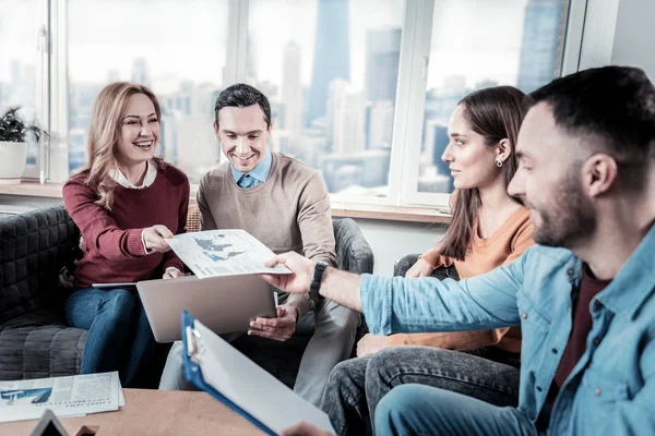 Amistosos trabajadores responsables sentados y usando el portátil . — Foto de Stock