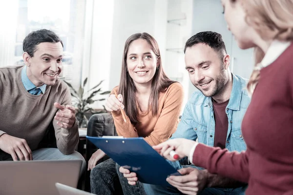 Ocupados trabajadores satisfechos sonriendo y pasando por alto el documento . — Foto de Stock