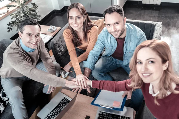 Freudig zufriedene Mitarbeiter, die zusammensitzen und geradeaus schauen. — Stockfoto