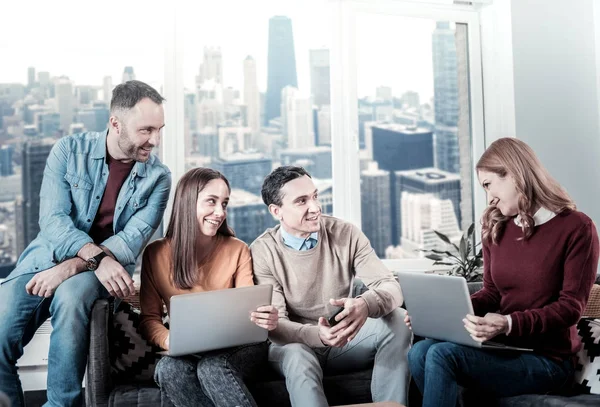Creative friendly colleagues sitting and holding laptops. — Stock Photo, Image