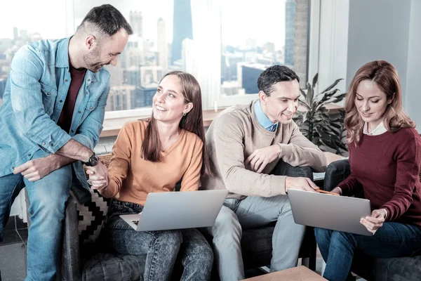 Intelligente, verantwortungsbewusste Mitarbeiter, die Laptops benutzen und kommunizieren. — Stockfoto