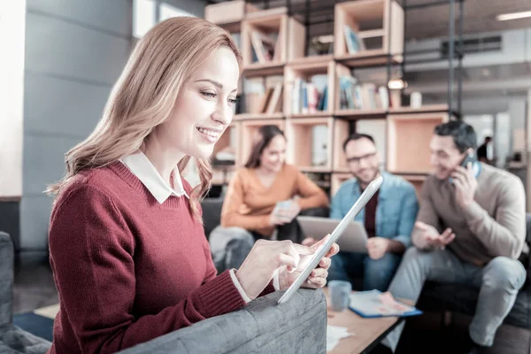 Mujer ocupada alegre sonriendo y usando la tableta . — Foto de Stock