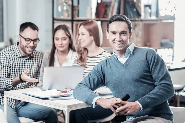 Knappe tevreden man zit door de tabel en op zoek rechte. — Stockfoto