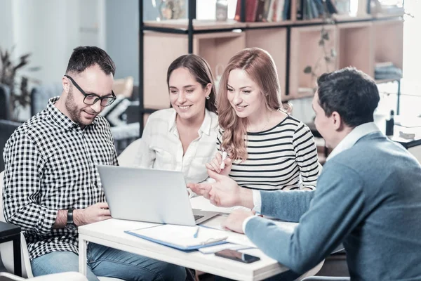 Nett aussehende, stilvolle Mitarbeiter, die den Laptop benutzen und dem Kollegen zuhören. — Stockfoto