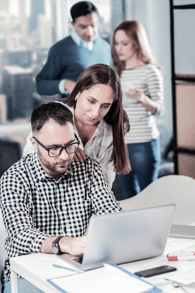 Милая приятная женщина стоит и держит за руку партнеров плечо
.