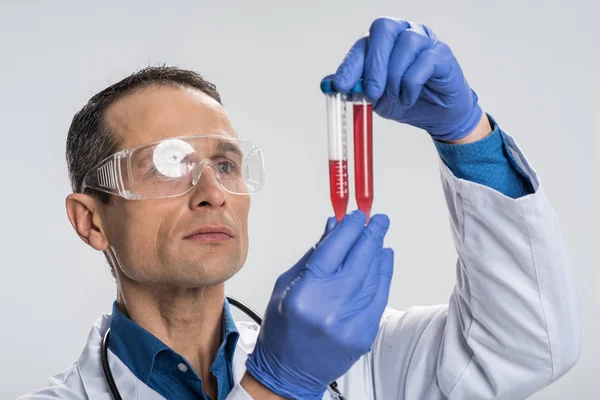 Elegante laboratorio masculino que examina la muestra de sangre —  Fotos de Stock