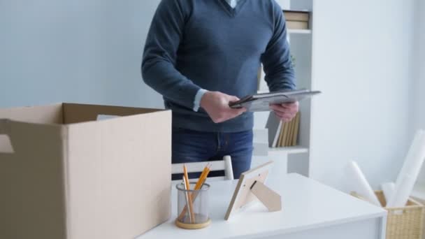 Joven hombre dejando la oficina y empacando sus cosas — Vídeos de Stock