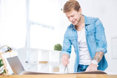 Bir çift bir pergel tutarak ve kendinden emin seyir sakin zeki mühendis