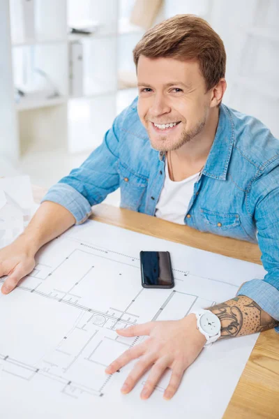 Ingegnere emotivo guardando fiducioso mentre seduto e sorridente — Foto Stock