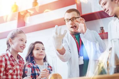 Komik öğretmen çocuklarla bilimsel deney sırasında aptal surat