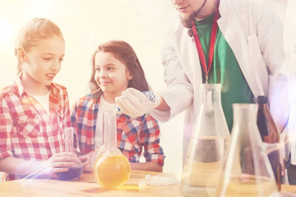 Los niños sorprendidos viendo a su maestro haciendo experimentos en el laboratorio de la escuela — Foto de Stock