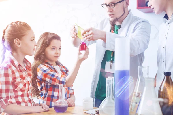 Smart schoolgirls participating in chemistry practical lesson — Stock Photo, Image