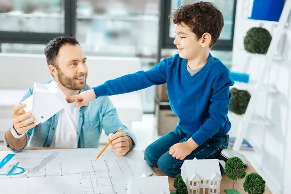 Ragazzino che indica un modello di casa nelle mani dei padri — Foto Stock