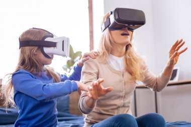 Anne ve çocuğu Vr kulaklık giyen konsantre