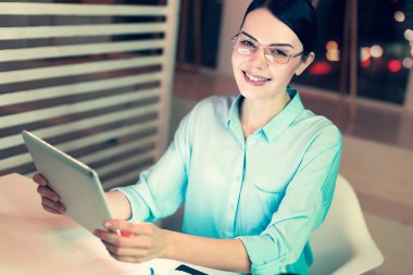 Sevimli kadın iş yerinde tablet kullanırken poz