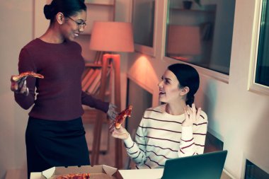 Neşeli arkadaşları birbirine incelerken pizza yemek