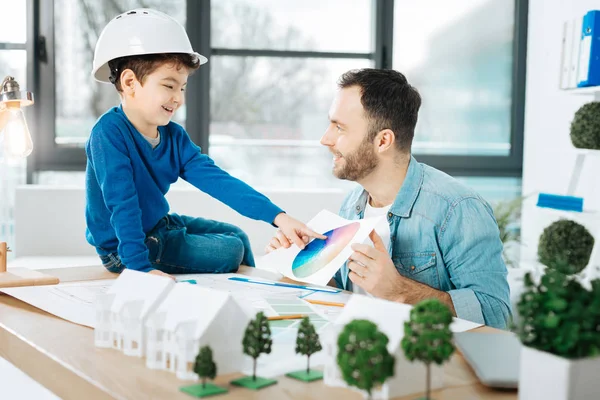 Angenehmer Architekt zeigt seinem Sohn eine Farbkarte — Stockfoto