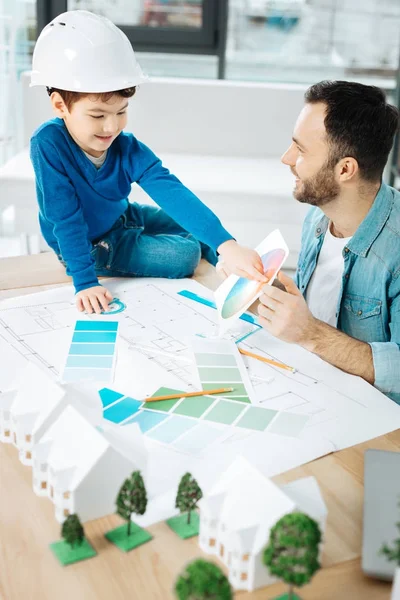 Charming architect discussing the color with his son