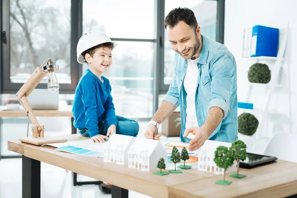 Architetto sorridente che spiega le basi del suo lavoro a suo figlio — Foto Stock