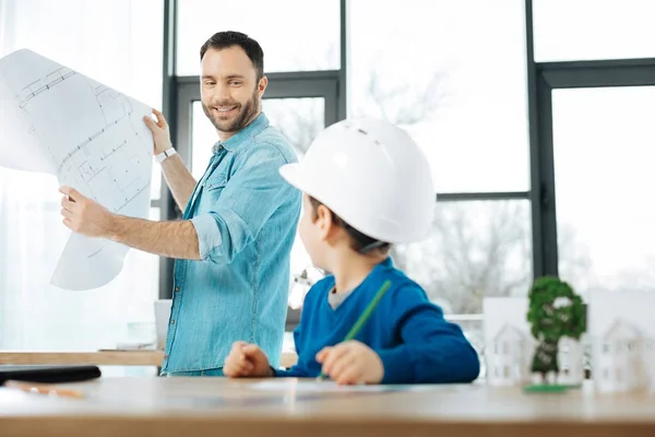 Little boy looking at his father holding blueprint — Stock Photo, Image