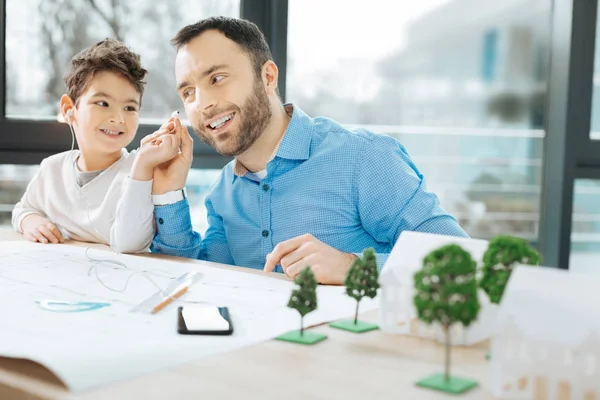 Cute boy sharing earpieces with his father — Stock Photo, Image