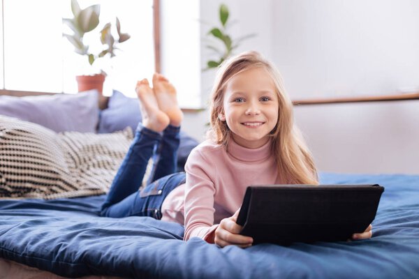 Веселая девушка отдыхает на кровати
