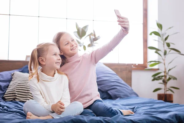 Irmãs inspiradas tirando fotos em seu telefone — Fotografia de Stock