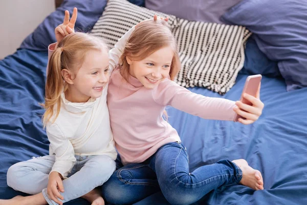 Sorrindo meninas de cabelos justos fazendo orelhas de coelho — Fotografia de Stock