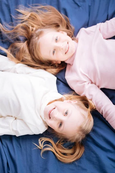 Joyful blond girls lying head-to-toe — Stock Photo, Image