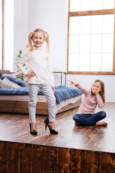 Schattig jongere zus dragen van moeders schoenen — Stockfoto