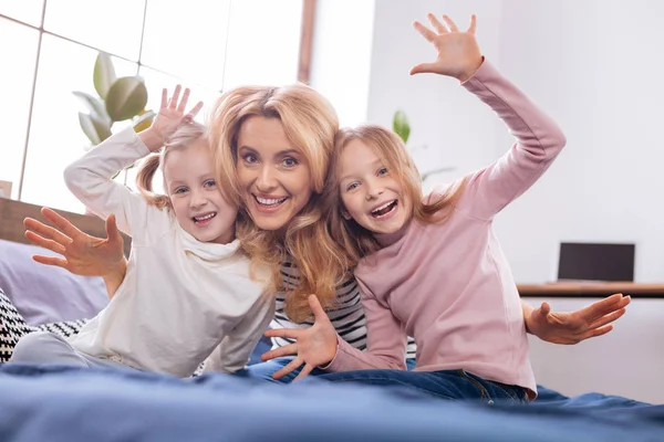 Mère inspirée et ses filles agitant leurs mains — Photo