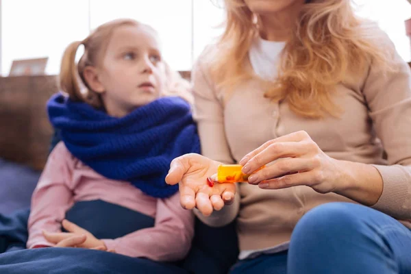 Грустная маленькая больная девочка принимает таблетки — стоковое фото
