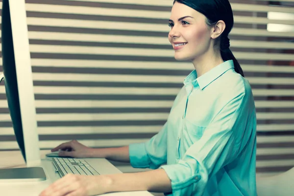 Bilgisayarda çalışan büyüleyici kadın yan görünüm — Stok fotoğraf
