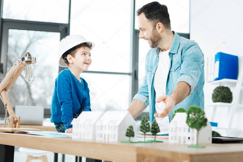 Cheerful architect talking about work with his son
