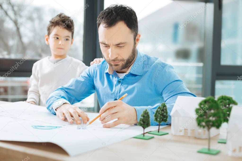 Busy architect paying no attention to his little son