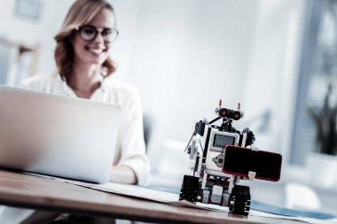 Küçük robot holding modern smartphone