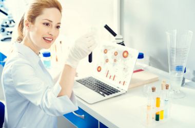 Yetişkin kadın laboratuarda çalışırken test tüpü analiz