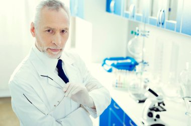 Poz ve kameraya bakarak ciddi olgun araştırmacı