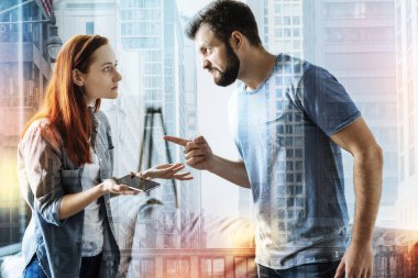 Genç çift ayakta ve kavga ederken kızgın hissediyor