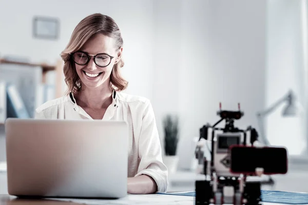 Cheerful female looking at screen of her computer