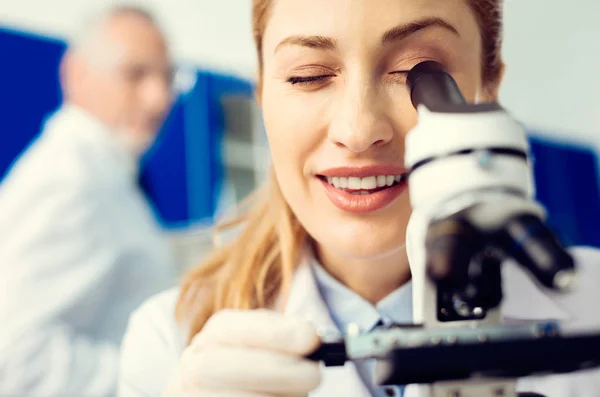 Primer plano de científico alegre usando microscopio en laboratorio —  Fotos de Stock