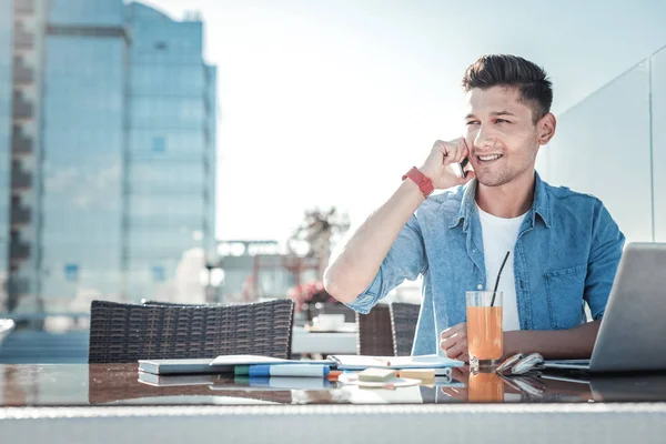 Молодий фрілансер розмовляє по телефону під час роботи на відкритому повітрі — стокове фото