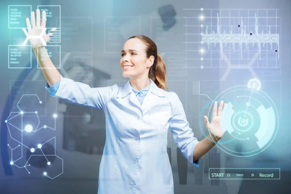 Allegro medico sembra felice mentre tocca schermo trasparente futuristico — Foto Stock