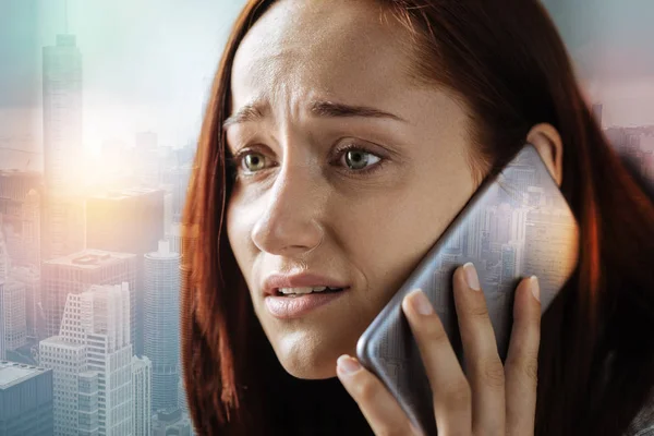 Donna preoccupata che sembra spaventata mentre parla al telefono — Foto Stock
