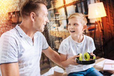 Duygusal çocuk babasına büyük kulaklıklar tutarken arıyorsunuz