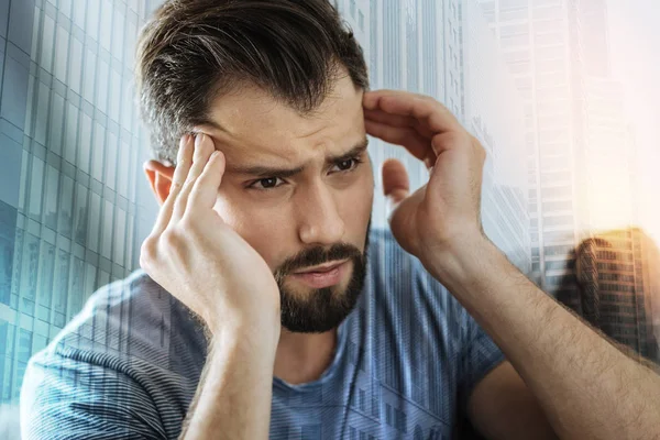 Tiefer ernster Mann, der zur Seite schaut und seinen Kopf berührt. — Stockfoto